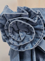 Close-up of a blue denim flower on a beige background