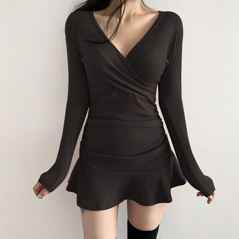 Black ribbed knit long sleeve V-neck bodycon mini dress with ruffle hem on model