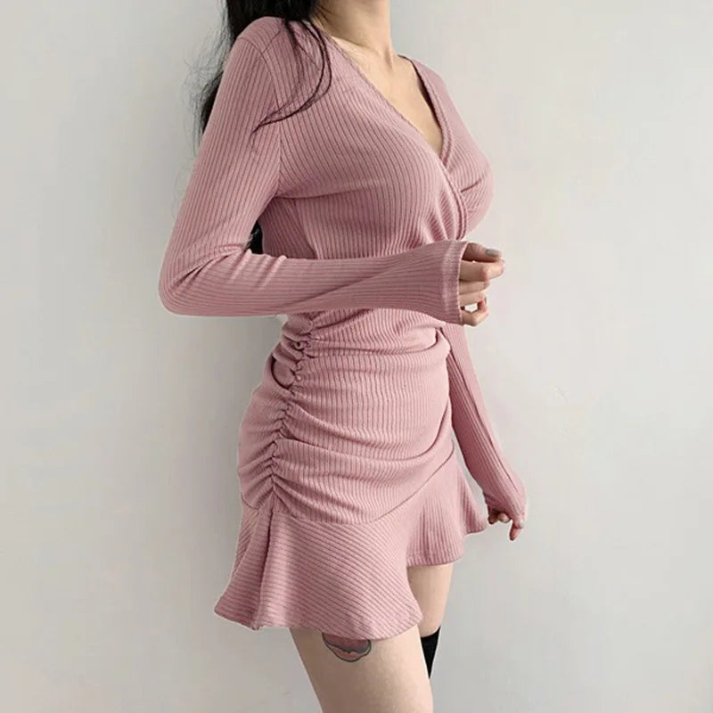 Pink ribbed knit long sleeve V-neck bodycon mini dress with ruffle hem on model